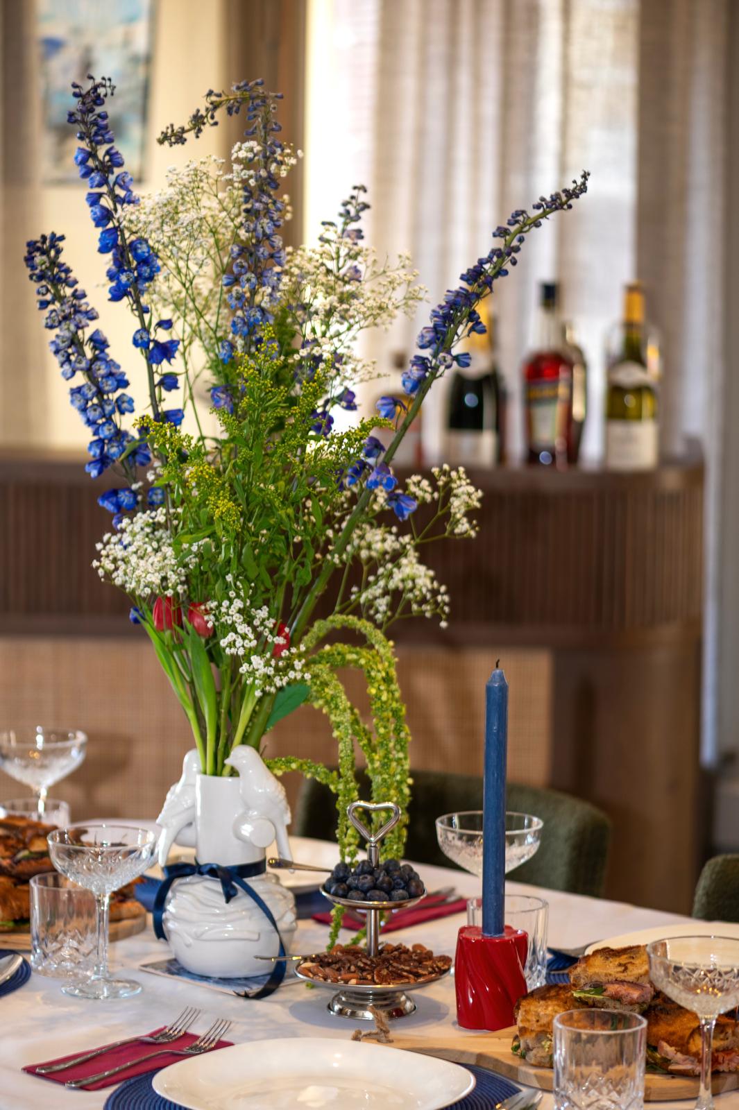 Elegant table setting with blue delphiniums, candles and Dutch styling